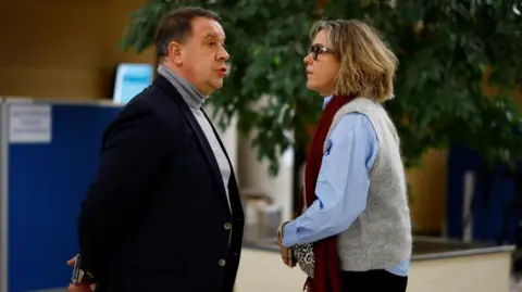 REUTERS/Sarah Meyssonnier Caroline Darian right and wearing a scarf talks to her brother David during a break in the Avignon trial