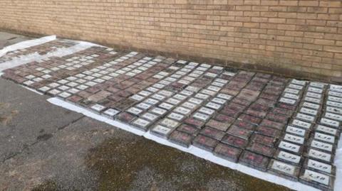 A car park with multiple packages on the ground allegedly containing cocaine