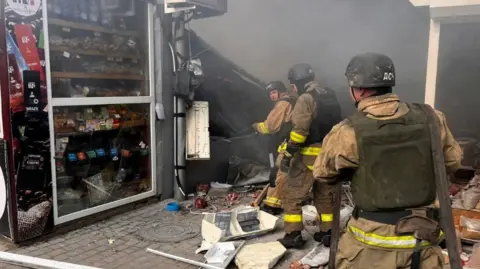 Firefighters work at a street market hit by a Russian drone strike, amid Russia's attack on Ukraine, in Nikopol, 4 April 2026