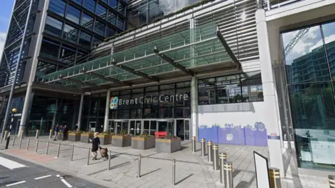 The exterior of the Brent Civic Centre building. It is a modern-looking building, with a glass facade. 