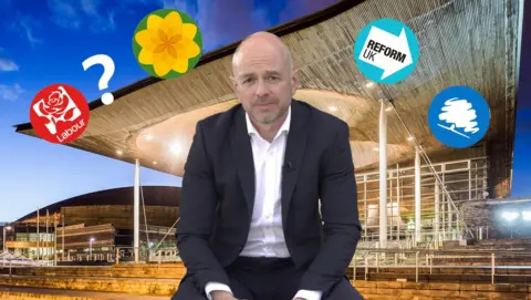 Gareth Lewis sits in front of a background of the Senedd with party political logos superimposed around his head