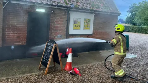 Worlingworth Swan A firefighter tackling a fire at Worlingworth Swan, Suffolk