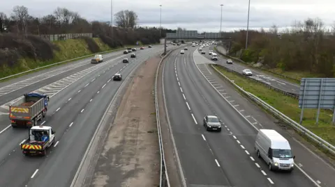 Several vehicles travel along sections of the M60 near Manchester