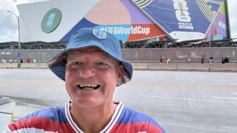 Darren Thompson Darren Thompson outside a stadium showing a World Cup game.