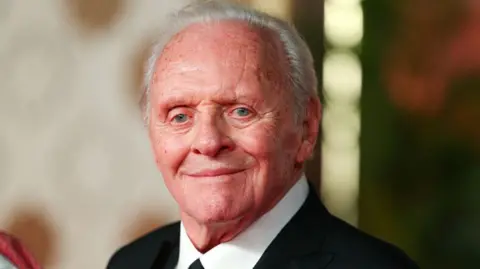 Sir Anthony Hopkins in a dark suit and tie