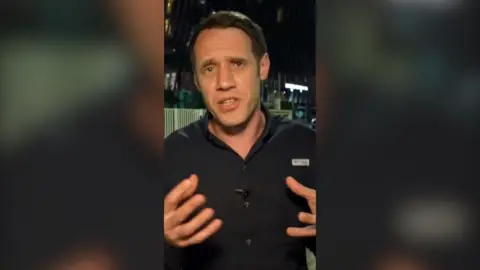 Will Grant has dark hair and is wearing a black shirt.