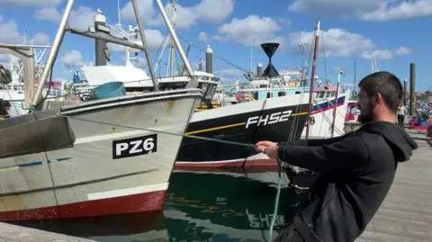 BBC A man pulling a fishing boat