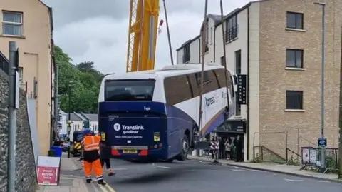 bus being lifted by crane
