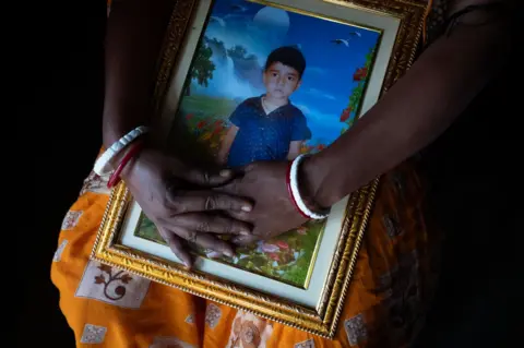 Swastik Pal Kakoli Das holds the image of her six-year-old son Ishan Das who drowned three months ago.