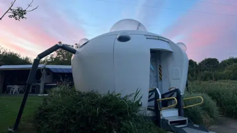 Melin Mabes Pod at dusk, with steps at the entrance