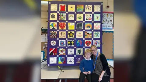 Penguin PR Paula Martin sat with a pupil in front of a quilted piece of art