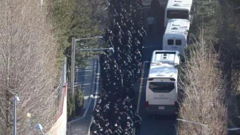 Reuters Police officers and investigators from the Office of Corruption of High-Ranking Officials leave the presidential palace on Wednesday morning