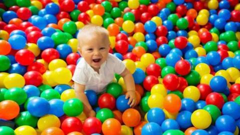 A toddler in a ball pit