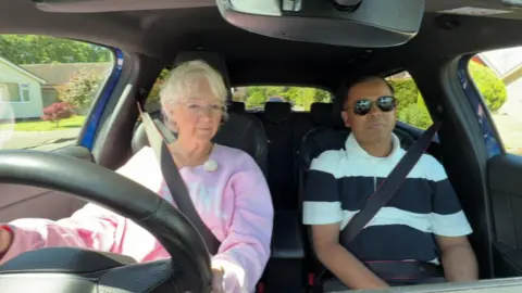 Olwen and Deen as driver and instructor in the car front seats during a lesson.