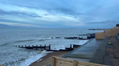 BBC / George Carden A beach with the tide coming in. The sky is grey