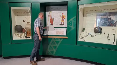 St Albans Museums Man looking at Roman exhibition at Verulamium museum