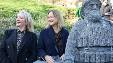 RNLI/Ceri Oakes Lesley Jackson (L) and Emma Stothard (R) next to the wire statue