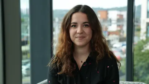 A young woman looking at the camera smiling