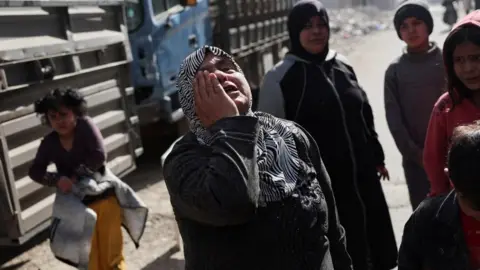 A woman holds her hand to her face in grief in the district of Tadamon in Damascus (file photo) 