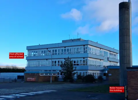 BBC Picture of three storey building that is a primary school with a boiler house and chimney also visible