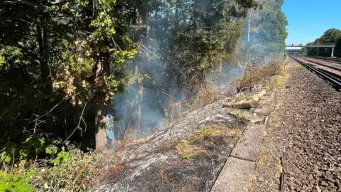 Smoke billowing from a lineside track. 