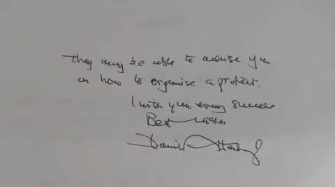 Family Handout A close up of a letter, which reads: they may be able to advise you on how to organise a protest. I wish you every success. Best Wishes David Attenborough.