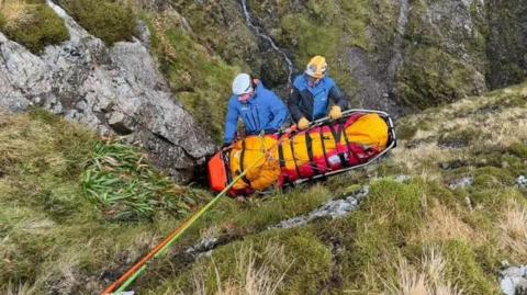 Mountain rescuers with a casualty on a stretcher