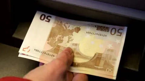 Generic image of a hand withdrawing 50 euro notes from a cash machine