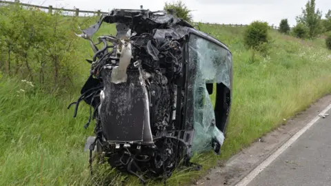 Durham Police A car on its side and desteriyed beyond all recognition