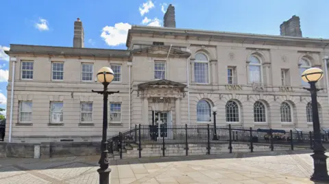 A image of nan beforehand of Rotherham Town Hall , a building successful achromatic stone, pinch 2 stories of arched windows.
