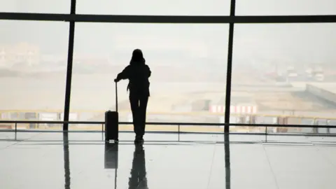 Getty Images A silhouette of a woman in an airport