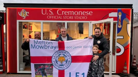 Supplied The family and their flag outside the Cremonese club store