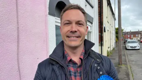 Andrew Turner/BBC James Clark on the campaign trail on Kitchener Road, Great Yarmouth