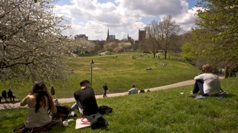 People sitting in a park in the sunshine