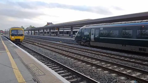 Oxford Train Station platform, with two trains passing each other.