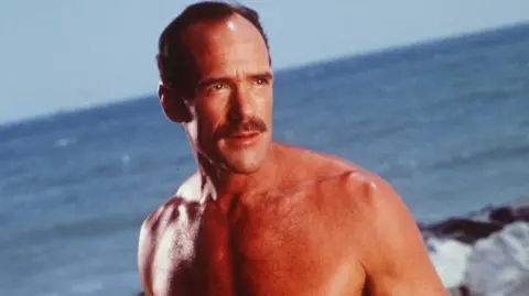 Getty Images Michael Newman in Baywatch, 1997, pictured looking over the beach with the sea in the background