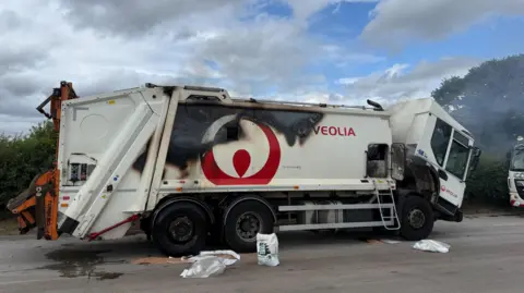 Nottinghamshire Fire and Rescue Service A white bin lorry stationary in the road, with clear scorch marks down the side