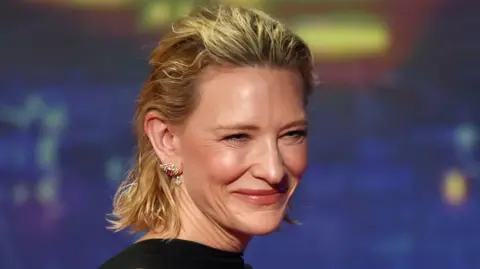 Cate Blanchett smiles whilst wearing sparkly earring