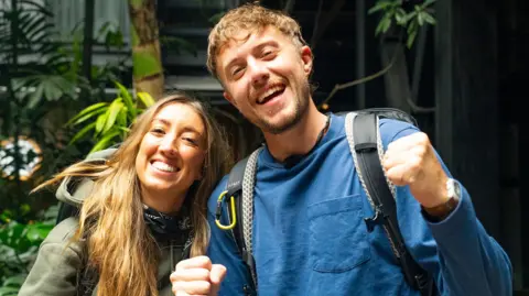 Harleymoon and Roman Kemp standing together and smiling during the race