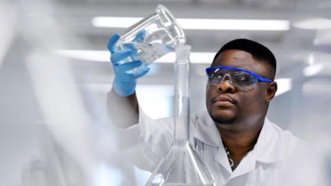 Dr Ojodomo Achadu of Teesside University pouring liquid in a laboratory