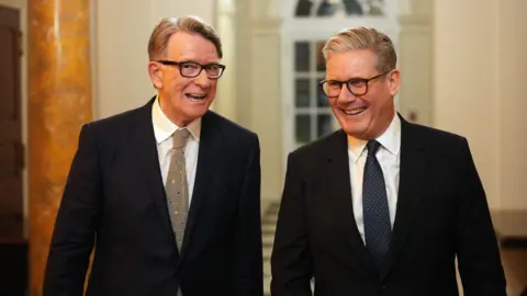 File photo dated 27/02/25 of Prime Minister Sir Keir Starmer (right) and British ambassador to the United States Lord Peter Mandelson during a welcome reception at the ambassador's residence in Washington, DC. Both are wearing dark suits, white shirts and patterned ties. They appear to be laughing. 
