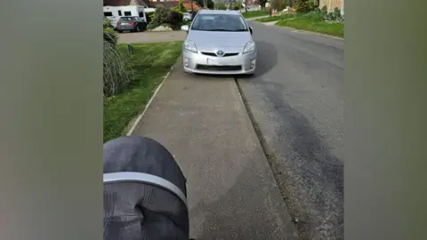 Louise Brown A silver car parked on the pavement