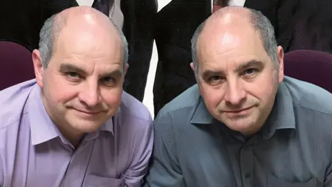Handout A picture of the twins today. The one on the left is wearing a purple collared shirt and the brother on the right is wearing a grey collared shirt. They look identical, with grey hair which is balding on the top and clean shaven, smiling at the camera and leaning slightly forward.
