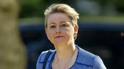 Getty Images Yvette Cooper walks up Downing Street in a blue suit
