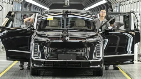 Employees inspect a Nio Inc. ES9 electric vehicle on the production line at the company's factory in Hefei, Anhui Province, China, on Tuesday, May 19, 2026. 