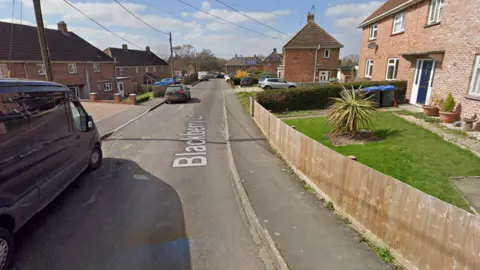 Google Maps Blackberry Lane in Potterne. There are houses and parked cars along the street