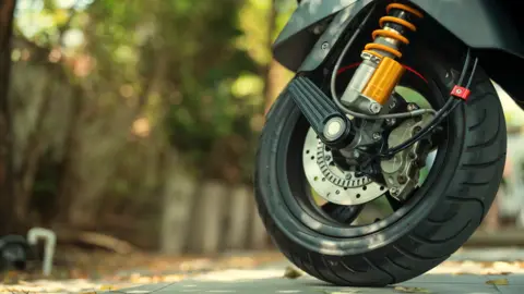 A close-up of a wheel on a motorcycle. 