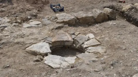 Steve Wallis, Dorset Council A medieval well, is circular with a stone lining. Archaeologists have only dug a relatively small amount of soil out of the middle.