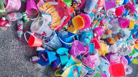 Weymouth and Portland Marine Litter Project A large pile of brightly coloured litter collected from the beach consisting mostly of beach toys, buckets and spades.