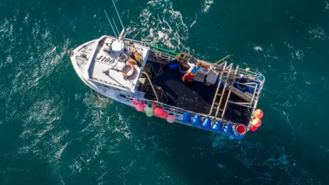 The image shows a bird's eye view of a fishing boat at sea.